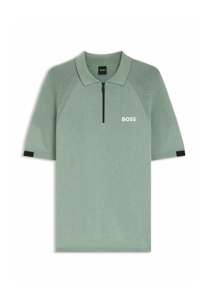 Polo vert clair à manches courtes avec manches côtelées, fermeture éclair noire à l'avant et logo blanc "BOSS" sur la poitrine gauche.