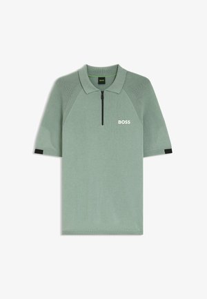 Polo vert clair à manches courtes avec manches côtelées, fermeture éclair noire à l'avant et logo blanc "BOSS" sur la poitrine gauche.