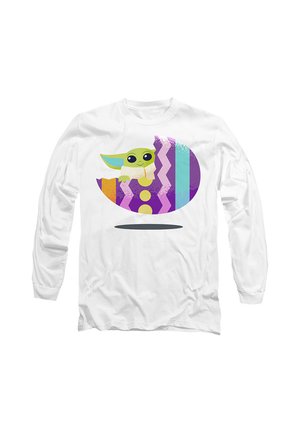 White long-sleeve shirt with a colorful graphic of a green cartoon character inside a patterned, partially cracked egg.