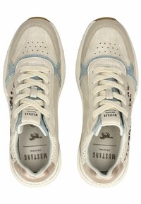 Baskets beiges avec des panneaux en cuir et en denim, détails perforés, accents bleu clair et semelle dorée. Lacets et logo visibles.