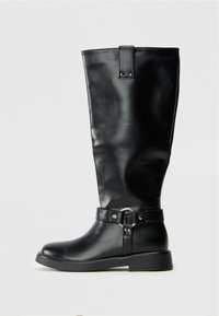 Bottes noires montantes en matériau synthétique lisse, avec un tige large, une accent en boucle en métal, et une semelle plate basse.