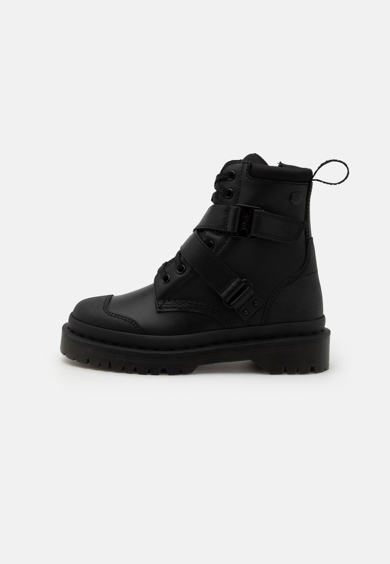Botte de combat en cuir noir avec semelle épaisse, deux sangles réglables avec boucles, lacets et languette de traction à l'arrière, vue de profil.
