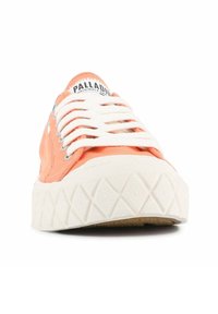 Pantofii sport din pânză portocalie, cu șireturi albe și o talpă din cauciuc alb texturată, prezintă modele în formă de diamant. Logo-ul este vizibil pe limbă.