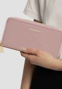 Cartera de cuero texturizado rosa con herrajes dorados y cremallera, que presenta el nombre de la marca "LAZAROTTI" grabado en la parte frontal.