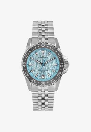 Nerezová oceľová hodinky s textúrovaným modrým číselníkom, so striebornými značkami a čiernym rámčekom. Obsahuje kovový náramok a je vodotesná do hĺbky 20 ATM.