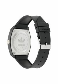 Montre avec un bracelet en caoutchouc noir et un boîtier en métal hexagonal. Dispose d'un fond en acier inoxydable avec le logo Adidas. Inclut des accents en métal argenté.
