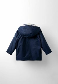 Marineblaue wasserdichte Jacke mit Kapuze, die ein einfaches Design und eine glatte Textur aufweist, vor einem weißen Hintergrund hängend.