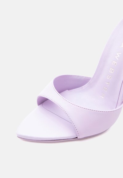Λιλά mule ψηλοτάκουνο με ανοιχτά δάχτυλα, με ένα φαρδύ εμπρόσθιο λουρί και ελαφρώς μυτερή μύτη σε λευκό φόντο.
