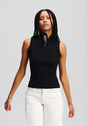 Top senza maniche nero a coste con colletto alto e chiusura con zip, dotato di un'etichetta con logo sul collo e design aderente.
