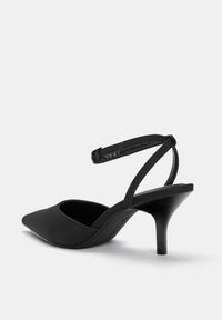 Črne visoke pete z ostrim nosom in ozkim gležnjakom, izdelane iz gladkega materiala, z elegantnim dizajnom in srednje visokim stiletto petom.