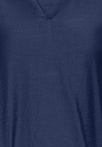 Maglietta blu navy a scollo a V in tessuto leggero, caratterizzata da una superficie leggermente texturizzata, con una vestibilità rilassata e senza motivi o accenti visibili.