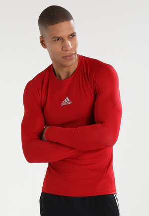Rotes Langarm-Sportshirt aus elastischem Material. Verfügt über einen runden Halsausschnitt und das Adidas-Logo in Silber auf der Brust.