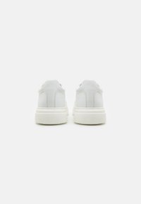 Witte leren sneakers met een gladde afwerking, voorzien van een gewatteerde kraag, subtiele stiksels en een dikke rubberen zool.