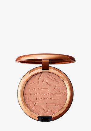 Poudre compacte pressée ton pêche embossée "MAC" avec des motifs géométriques, logée dans un boîtier circulaire brillant en or rose avec un couvercle à rabat.