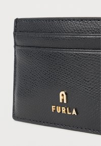 Black textured leather cardholder with multiple slots, featuring a gold embossed "A FURLA" logo at the bottom. Stitched edges visible.