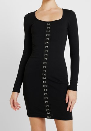 Robe noire à manches longues avec un décolleté carré, présentant un panneau central orné d'accents en métal argenté courant le long de l'avant.