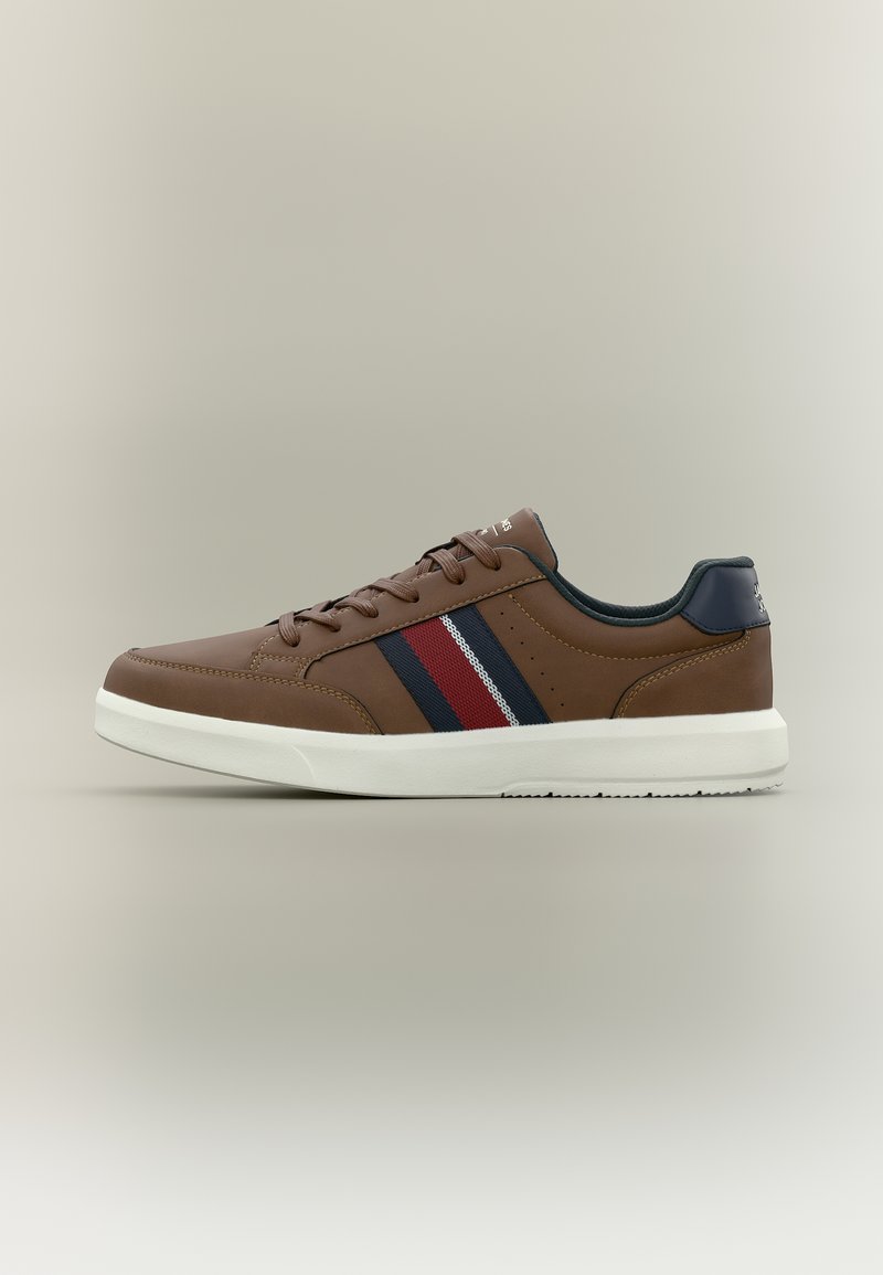 Καφέ αθλητικό παπούτσι χαμηλού προφίλ με λευκή σόλα, δέσιμο με κορδόνια μπροστά και υφασμάτινη λεπτομέρεια με ρίγες σε μπλε ναυτικό, κόκκινο και λευκό στο πλάι.