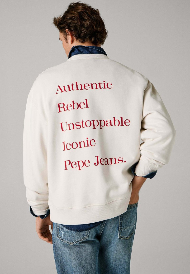 Felpa bianca con scritta rossa sul retro: "Authentic Rebel Unstoppable Iconic Pepe Jeans." Polsini e orlo a costine, vestibilità casual.
