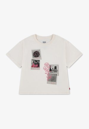 Hvid T-shirt med korte ærmer med sort-hvide fotopatches og pink blomster og tekst detaljer foran.
