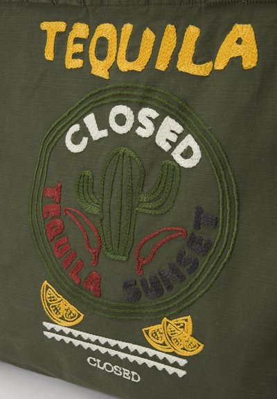 Zelená látka so farebnou výšivkou. Dizajn obsahuje slovo "TEQUILA," kaktus, červené papričky a citróny so slovom "CLOSED" nižšie.