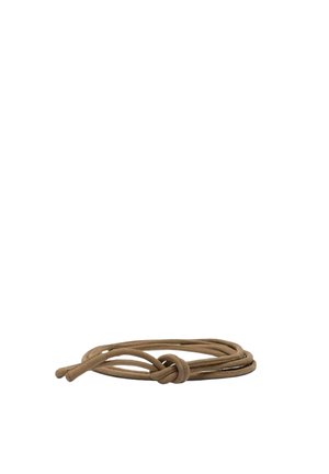 Lacet marron noué d'un nœud simple, enroulé librement sur un fond blanc.