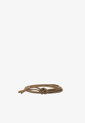 Lacet marron noué d'un nœud simple, enroulé librement sur un fond blanc.