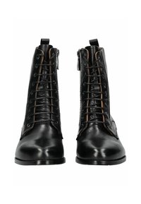 Botas de cuero negras hasta el tobillo con un diseño de cordones y acentos de ojales marrones, y un zipper lateral; textura suave con punta redonda.