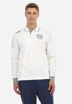 Polo de manga larga en algodón blanco con cuello y puños grises. Presenta un logotipo bordado en el pecho y en el hombro izquierdo.