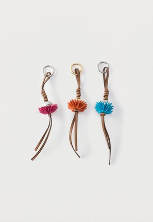 Drie leren sleutelhangers met ronde metalen ringen, elk voorzien van een kleurrijk bloemvormig leren accent in roze, oranje en blauw.