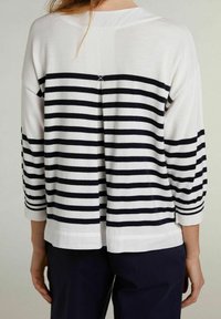 Striped sweater with a white and navy design, three-quarter sleeves, and a distinctive back detail. Made of soft, textured fabric.