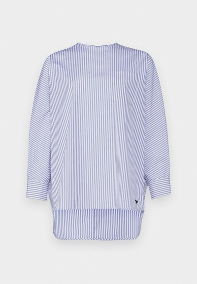 Ριγέ μπλούζα σε ανοιχτό μπλε και λευκό βαμβάκι. Διαθέτει στρογγυλή λαιμόκοψη, μακριά μανίκια, τσέπη στο στήθος και καμπυλωτό στρίφωμα με πλάγιες σχισμές.