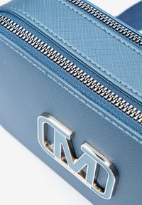 Borsa rettangolare blu con una superficie texturizzata. Presenta una cerniera e accessori in argento con le lettere "MD" in evidenza sulla parte frontale.