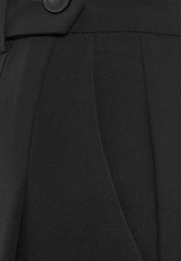 Schwarzer Stoff mit einer glatten Textur, versehen mit einer Faltendetail und einem flachen Knopf. Das Material ist opak und eng gewebt.