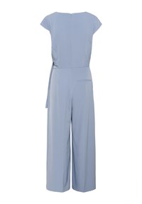 Jumpsuit azzurro chiaro con maniche a cappuccio, vita legata, design a gamba larga e cerniera sul retro. Include una tasca posteriore per un tocco di dettaglio.