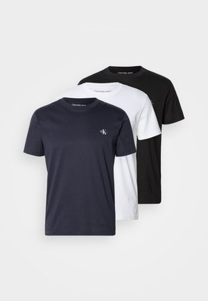 Three crew-neck T-shirts in navy, white, and black, made of cotton. Each features a small "CK" logo on the left chest.