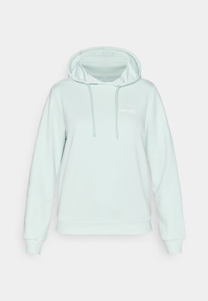 Miętowo zelená mikina s kapucňou a voľným strihom. Obsahuje klokaní vrecko, kapucňu so sťahovacou šnúrkou a malé biele logo na hrudi.