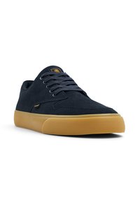 Zapatillas de ante azul marino con suela de goma, puntera redonda y cordones planos. Presentan una costura mínima y un logotipo en la lengüeta.