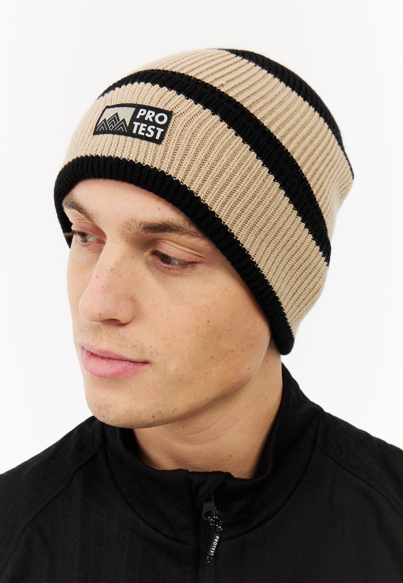 Gebreid beanie in beige met zwarte strepen, voorzien van een logo-opdruk, nauwsluitend ontwerp en ribbelstructuur.