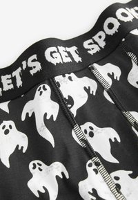 Schwarze Boxershorts mit einem weißen Geistermuster. Der elastische Bund trägt den Text "LASST UNS GRUSLIG WERDEN" in einer stilisierten, fetten Schrift.