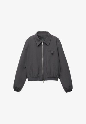 Jachetă zip-up de culoare gri închis, cu guler lat, manșete și tiv elastic, două buzunare laterale și un mic buzunar cu clapetă pe piept.