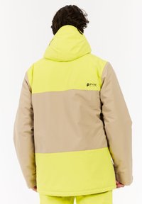 Geel en beige kleurgeblokte waterdichte jas met een capuchon, logo-detail en een losse pasvorm. Gemaakt van een glad synthetisch materiaal.