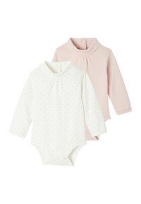 Two long-sleeve bodysuits: one white with gold polka dots, one solid pink. Both feature round necks and snap closures at the bottom.