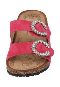 Pink suede slide sandal with two wide straps adorned by jeweled buckles, cork footbed, textured sole, and subtle detailing on the insole.