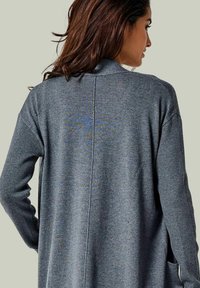 Grauer, gestrickter Cardigan mit einem schlanken Design, ausgestattet mit gerippten Ärmeln, Seitentaschen und einem zentralen Rückennahtdetail.