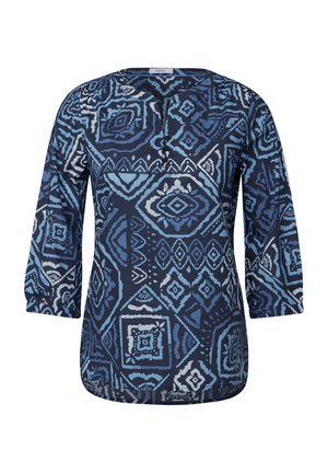 Blouse bleu marine à manches trois-quarts, avec un motif géométrique dans des tons de bleu et de blanc. Encolure ronde avec trois boutons.