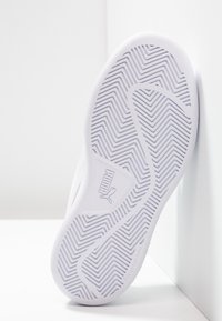 Suola di sneaker bianca con una superficie in gomma testurizzata caratterizzata da un motivo a zig-zag. Il logo del marchio è visibile sul lato.