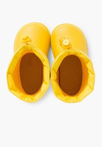 Bottes étanches jaunes avec des orteils ronds et des semelles texturées. Intérieur doublé d'un matériau brun doux. Présente un accent de bouton central.