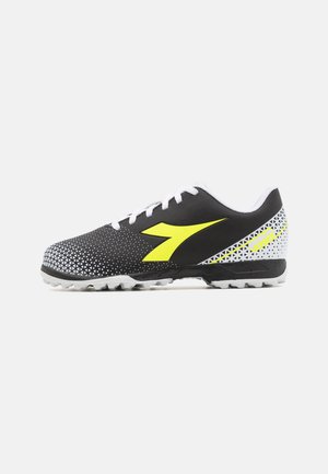 Scarpe sintetiche nere con un motivo geometrico bianco, dettagli gialli e lacci bianchi. Presentano una suola testurizzata per una migliore aderenza.