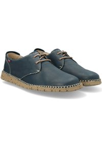 Zapatos de cuero azul con un acabado texturizado, punta redonda y cordones marrones. Suela de corcho con costuras en contraste. Diseño ligero y casual.