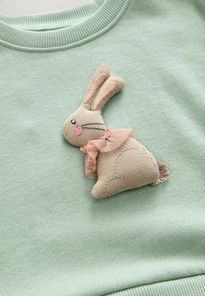 Mintgrøn sweatshirt med en blød, appliké kanin i beige med lyserøde accenter og en flæset krave, samt broderede detaljer på stoffet.